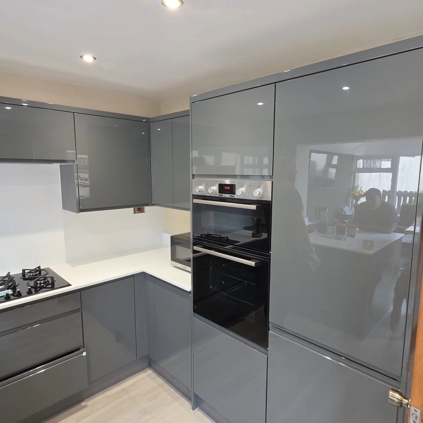 Integrated Bosch double oven set within tall grey gloss kitchen units
