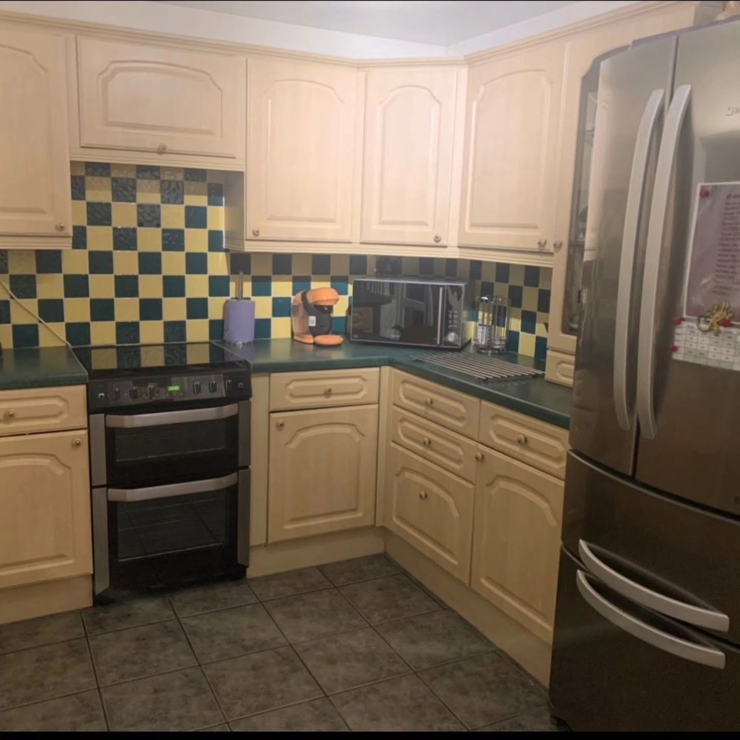 Dated kitchen with cream cabinets and tiled flooring before its modern Wren transformation