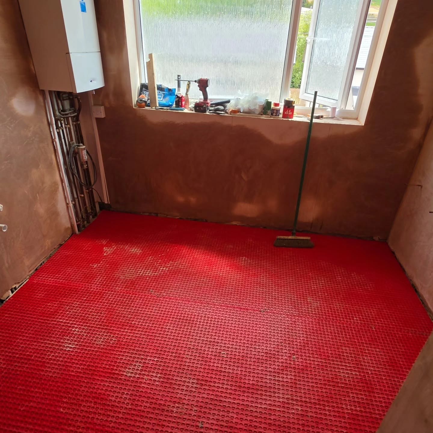 During the works: freshly plastered walls and decoupling membrane installed to the bathroom floor