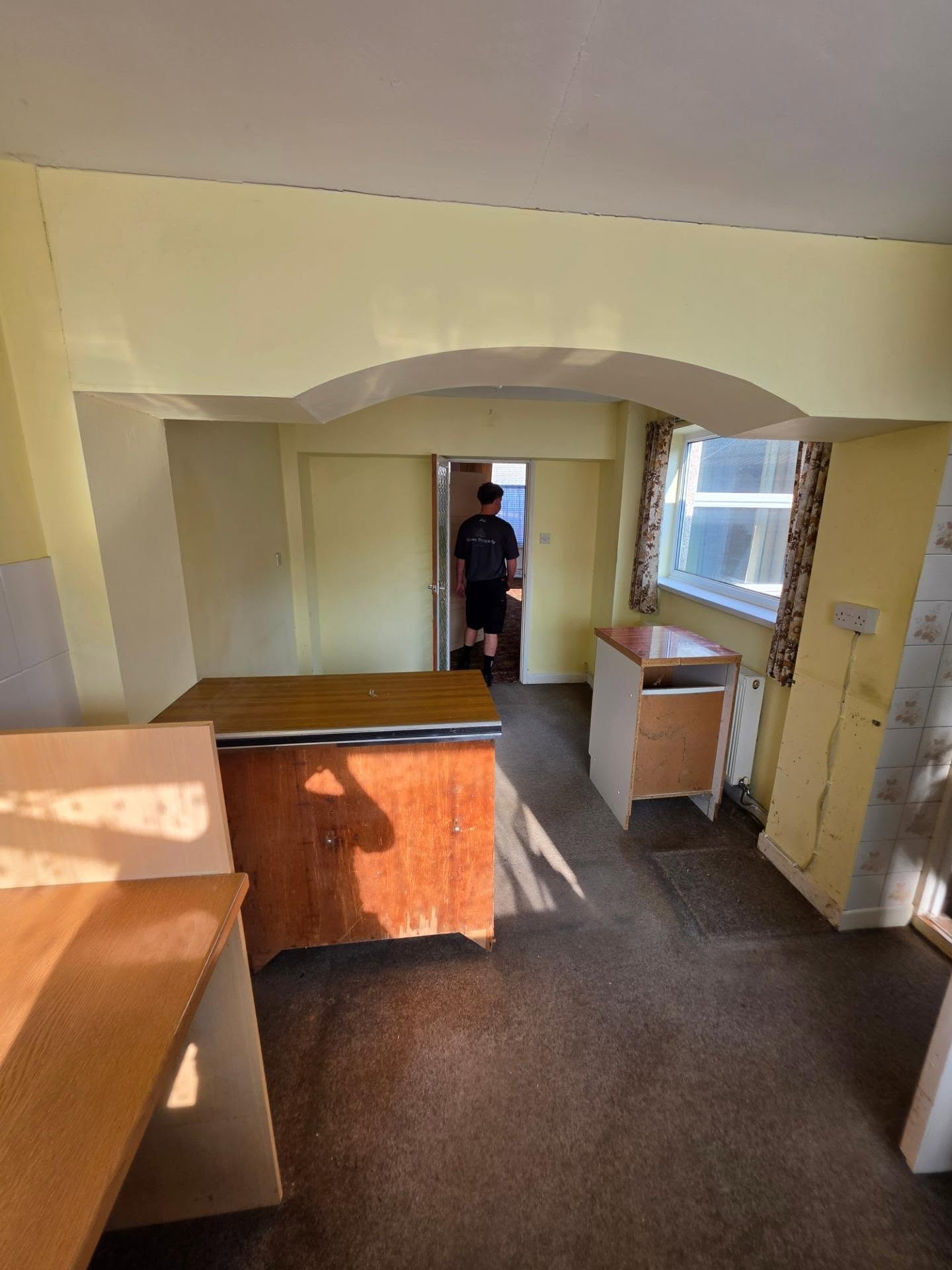 Before: separate dining area with arch and old units ahead of the open-plan kitchen