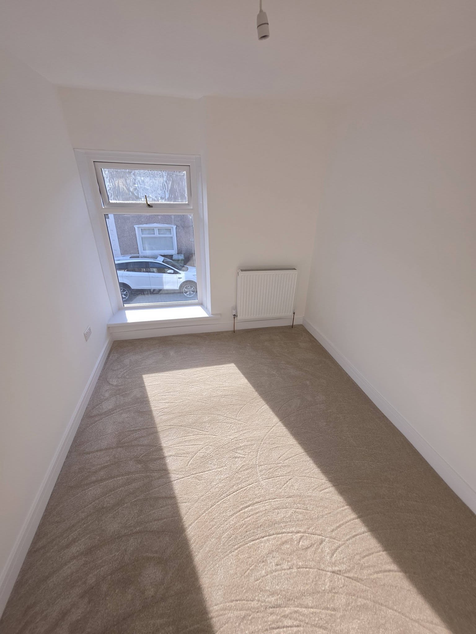 Front bedroom with a new replacement uPVC window, radiator and Topez carpet