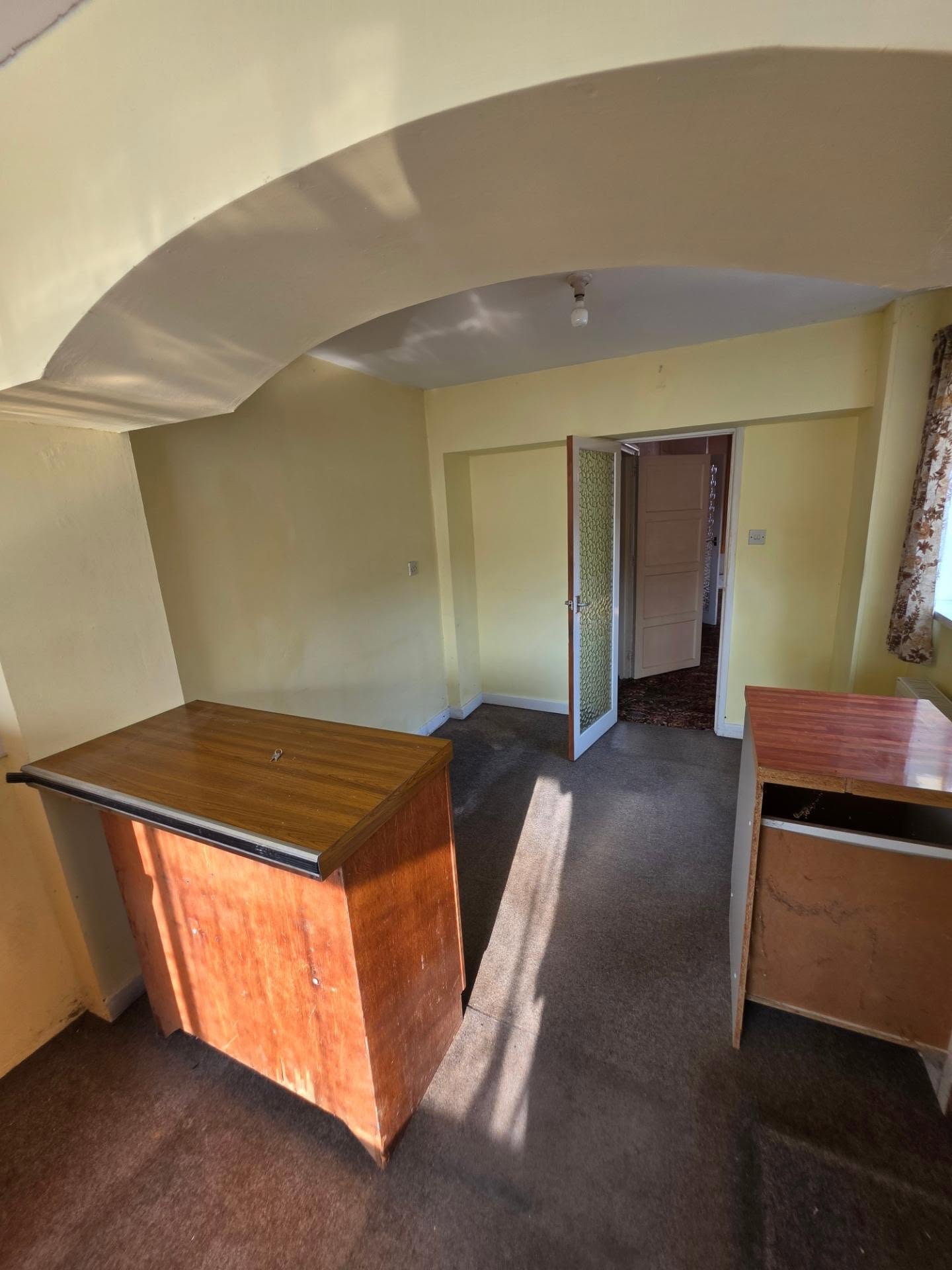Before: kitchen and dining area with arched opening, removed to create the open-plan layout