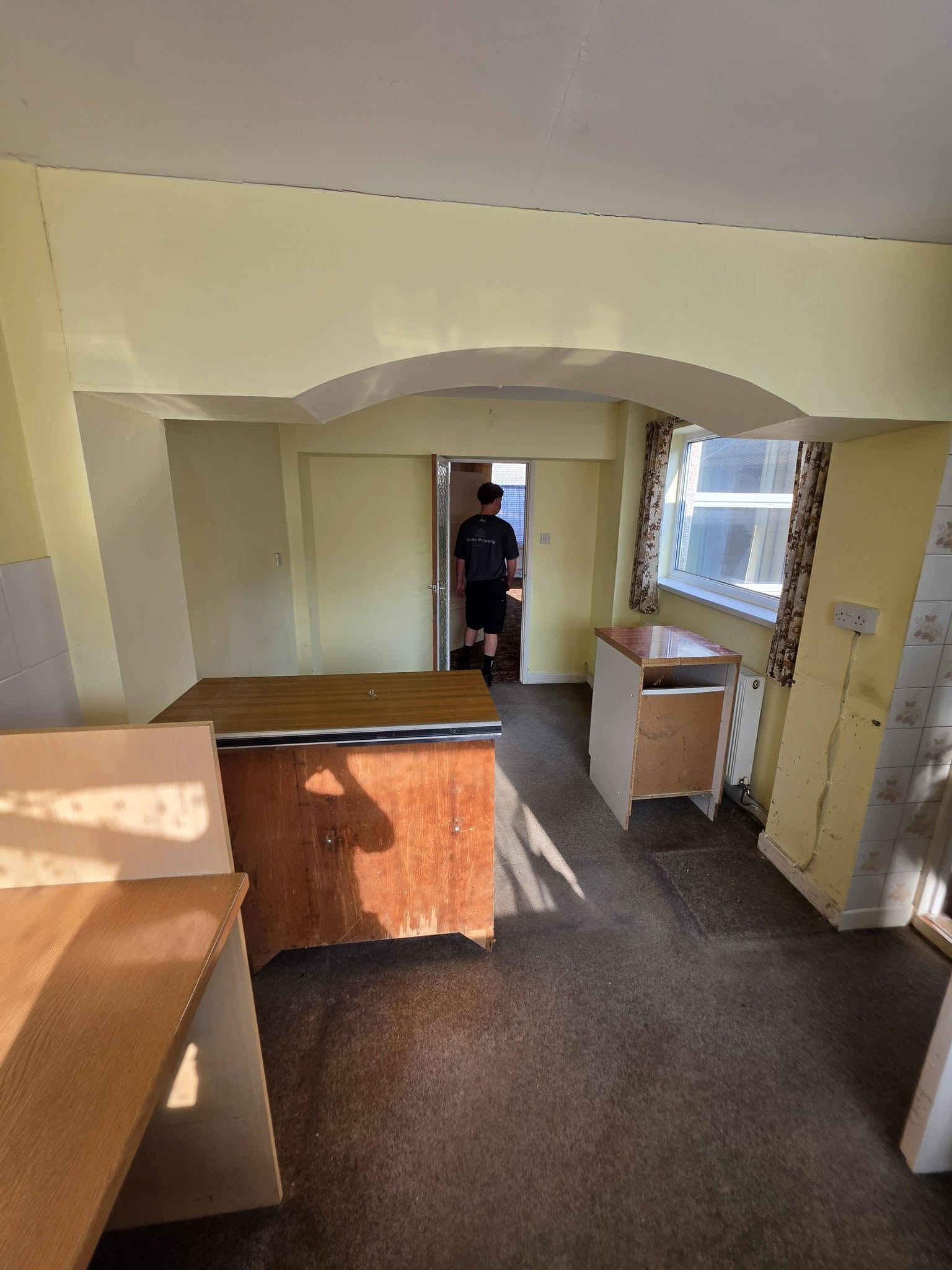 Before: kitchen and dining area with arched opening and old units