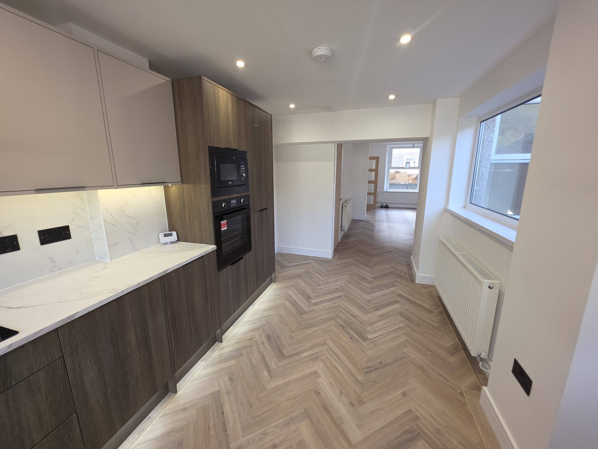 Renovated kitchen leading through to the dining area with Naked Blonde Oak herringbone LVT