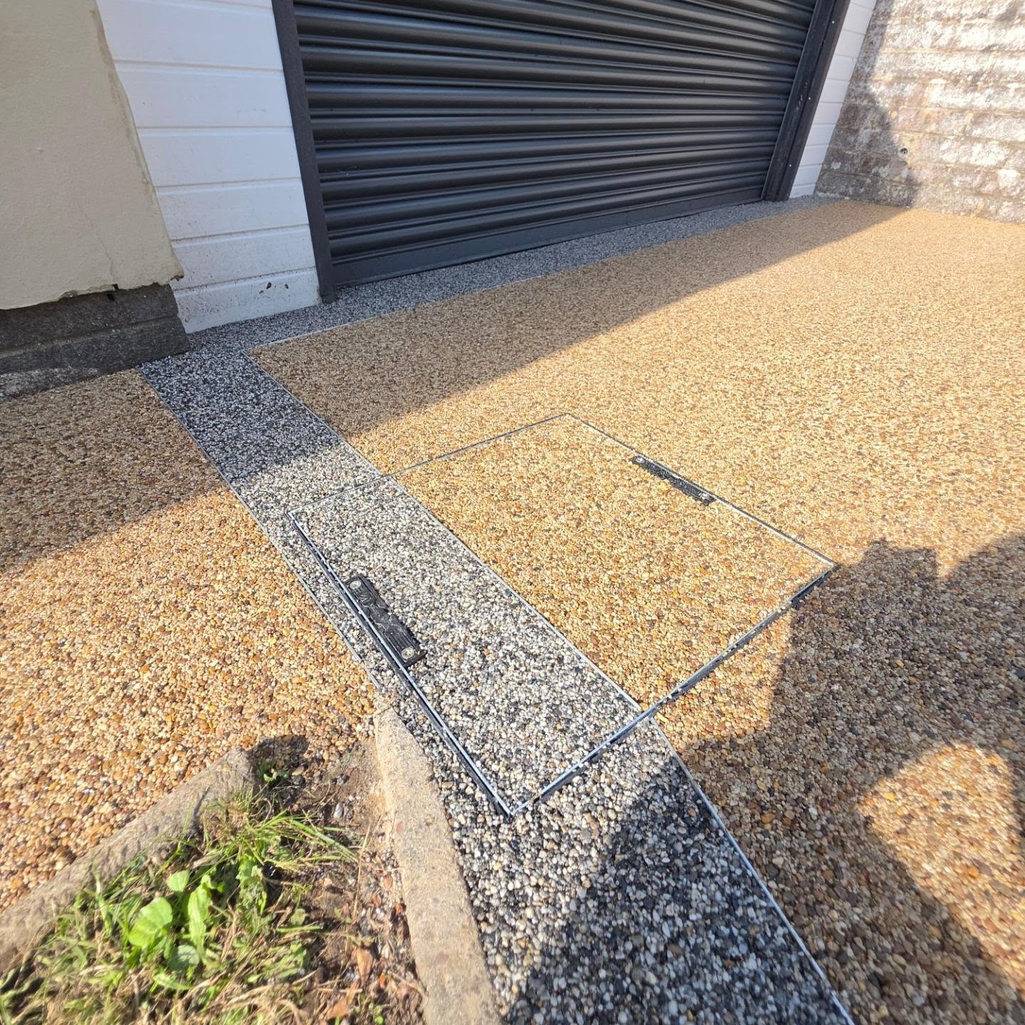 Matterhorn resin border and recessed manhole cover in front of the garage door