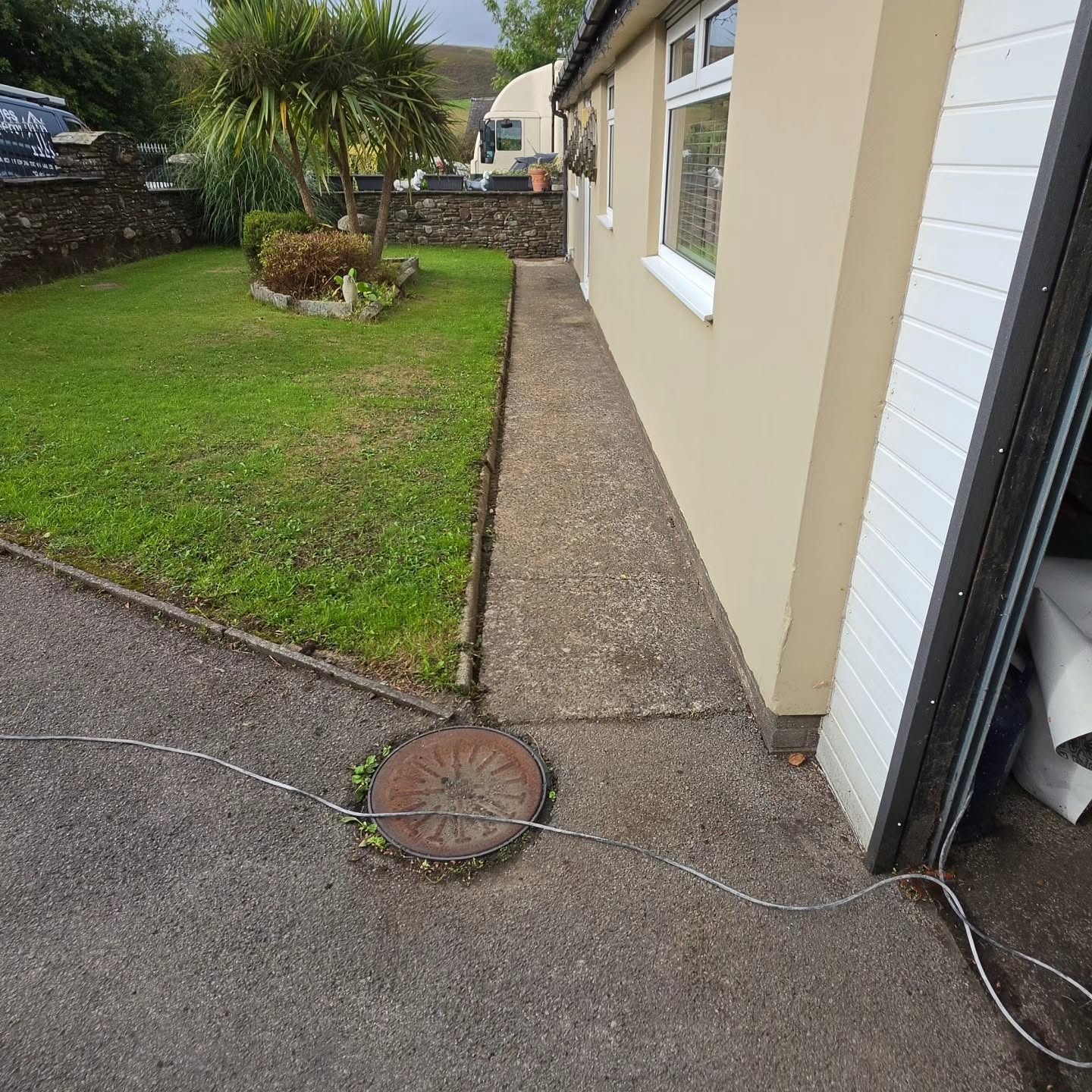 Before: side pathway with an old manhole cover prior to the resin installation