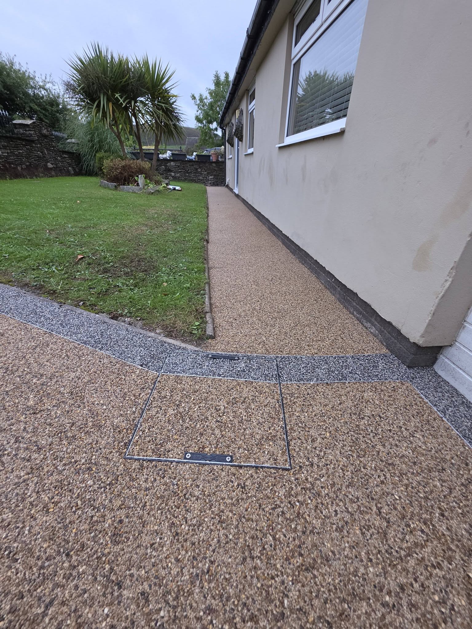 Kilimanjaro resin pathway running along the bungalow with a Matterhorn border against the lawn