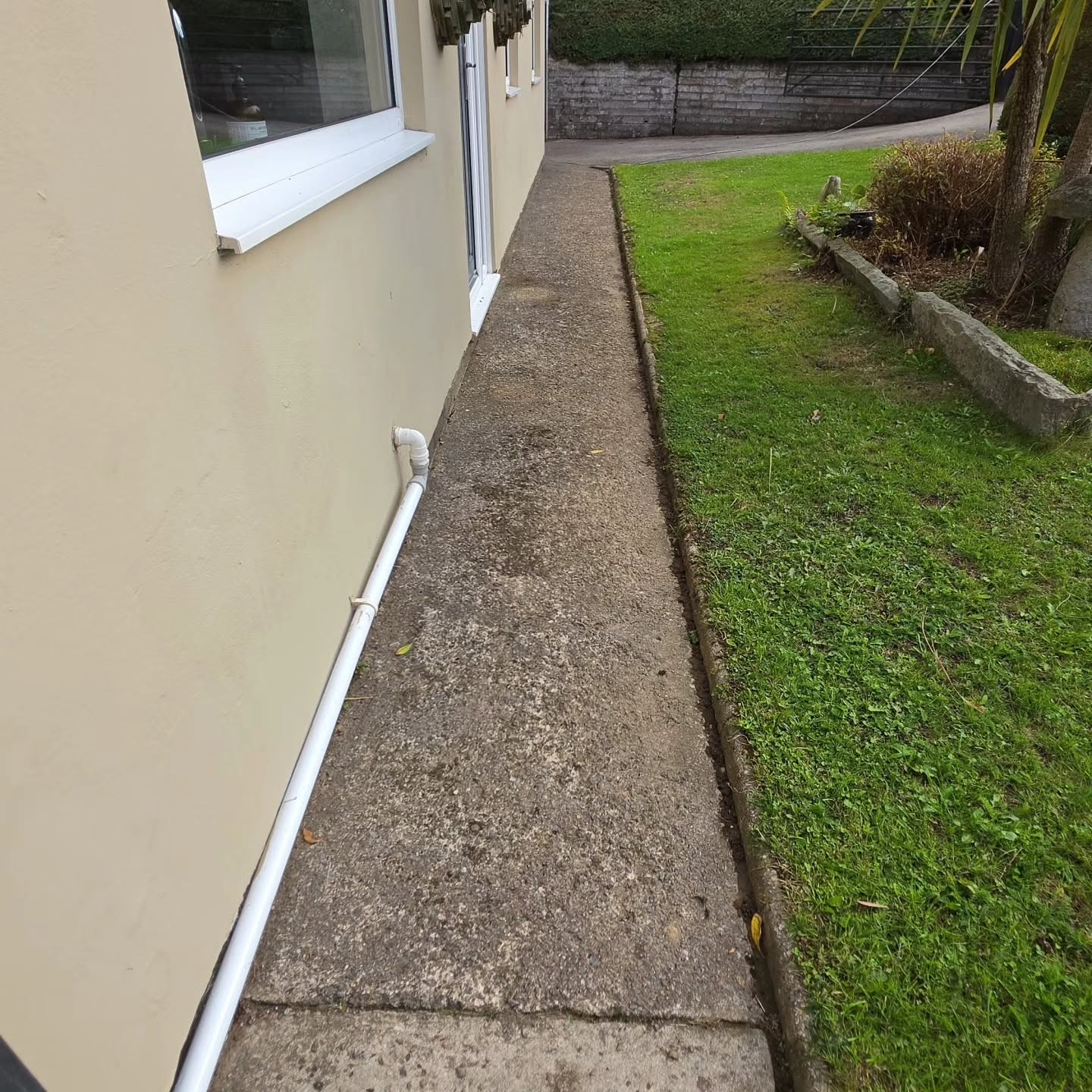 Before: worn concrete side path along the house