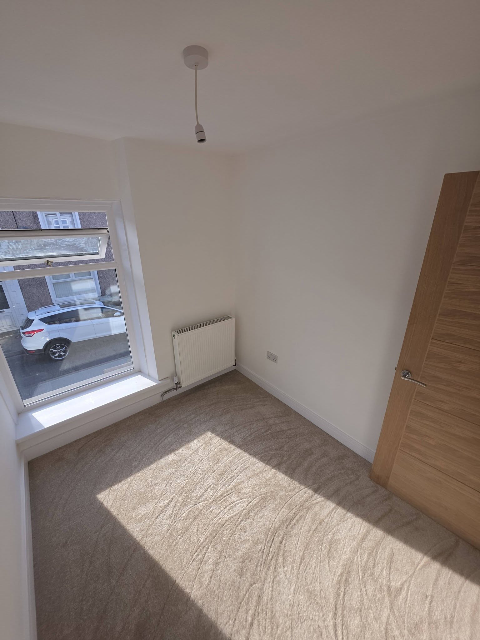 Bedroom in the reconfigured layout with replacement window and new carpet